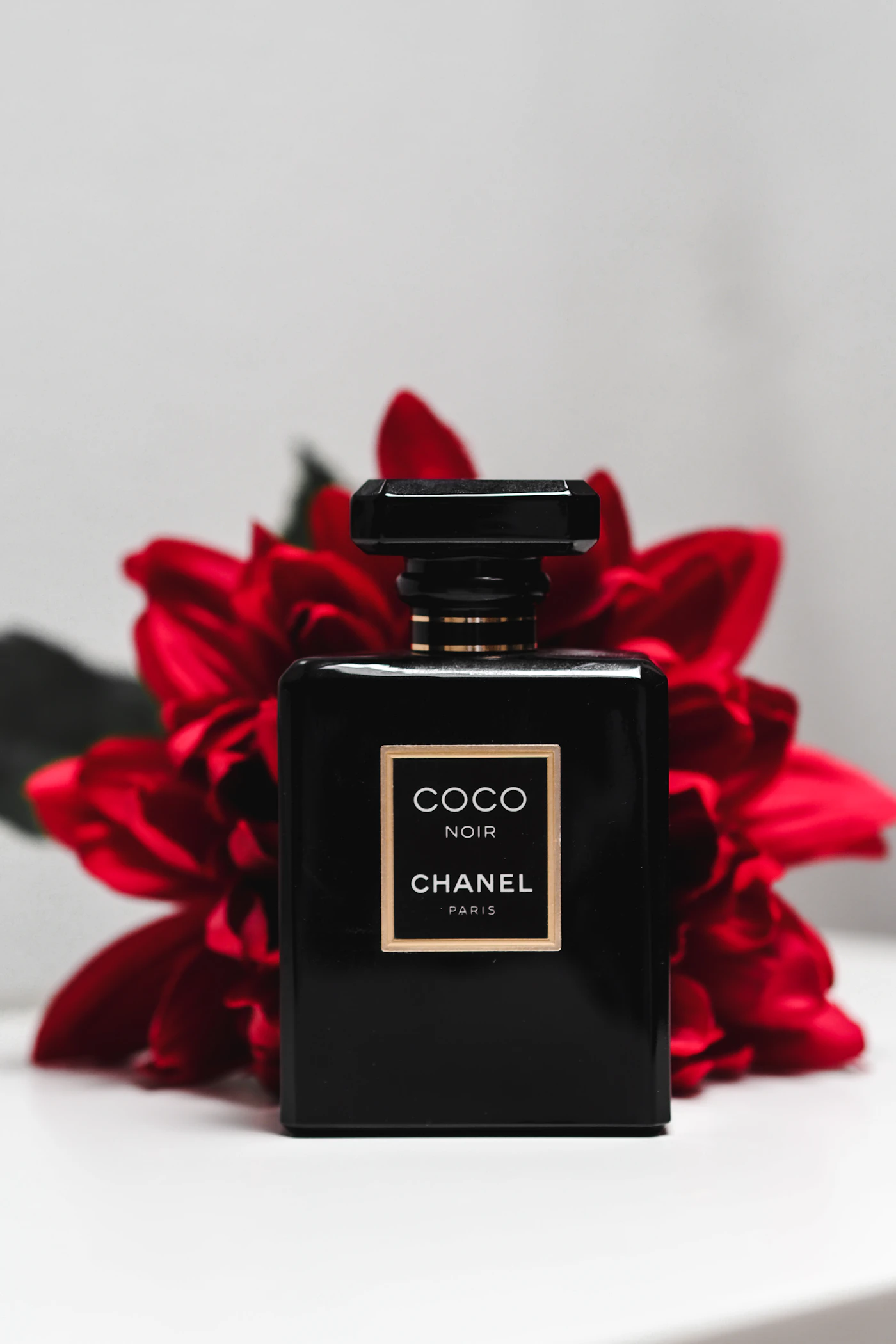 Parfum noir devant un bouquet rouge